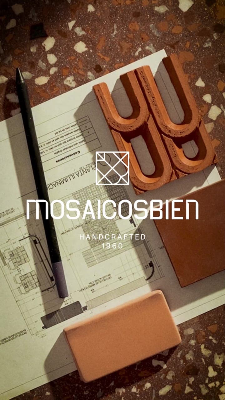 Planos, lápiz y piezas de cerámica sobre terrazo con el logo de Mosaicos Bien